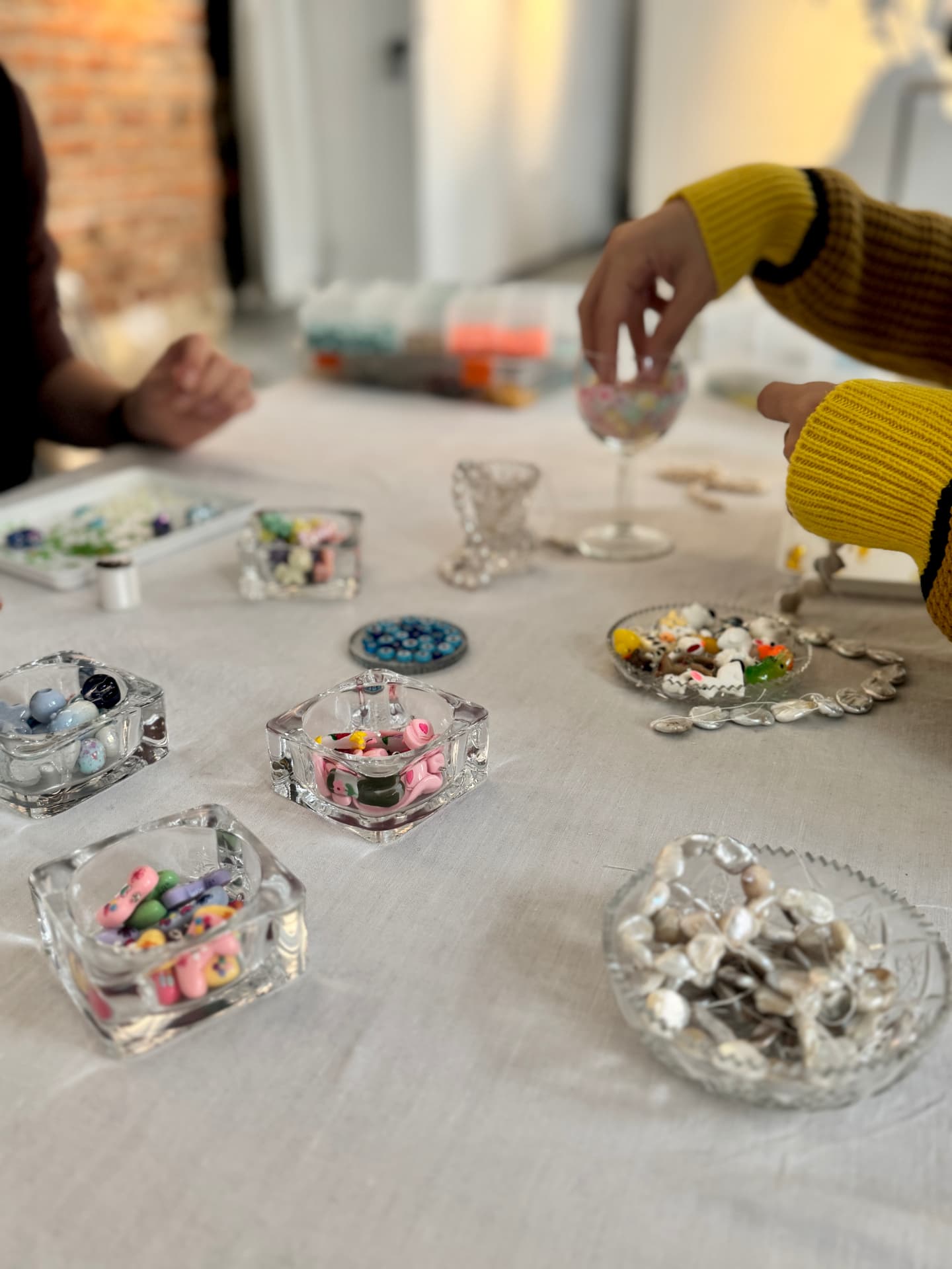 Glass bowls of colourful beads on the workshop table while makers browse