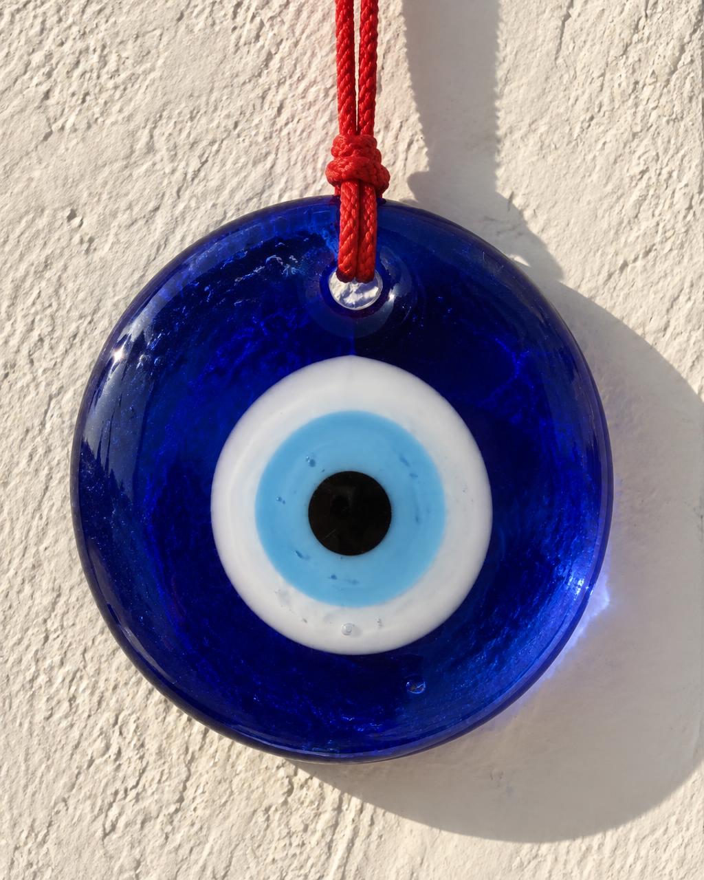 A hand-strung strand of blue nazar boncuğu glass eye beads resting on folded linen — an illustrative image